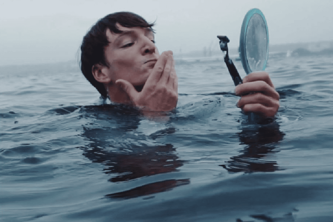 Mann rasiert sich im Wasser